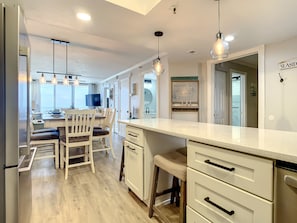Spacious breakfast bar with stylish lighting, overlooking the dining area and living space.