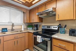 Fully stocked kitchen with stainless steel appliances, granite countertops, and a cozy, inviting ambiance.