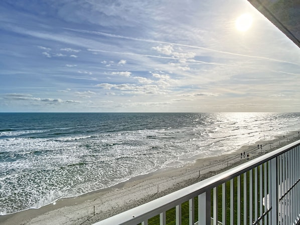 Breathtaking view of the sun rising over the ocean, casting golden light on the waves.