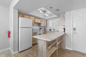 Chic kitchen featuring ample counter space, convenient shelving, and a blend of coastal-inspired and modern finishes.