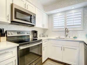 Well-lit kitchen with a spacious layout, perfect for preparing meals and enjoying the ocean-inspired decor.