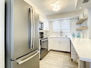 Contemporary kitchen showcasing a modern fridge, oven, and dishwasher in a cohesive design.