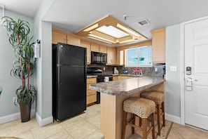 Fully equipped kitchen featuring a convenient breakfast bar and stylish decor.