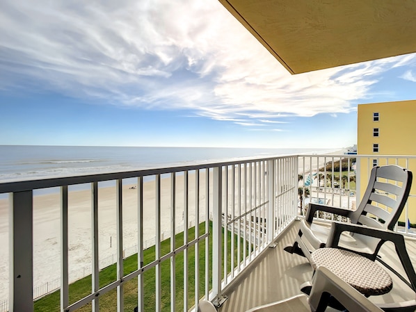Unwind on the private balcony, offering panoramic views of the ocean and beach.