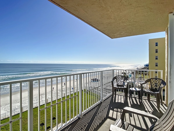 Private balcony with seating overlooking the beach, ideal for unwinding with panoramic coastal views and fresh sea breeze.