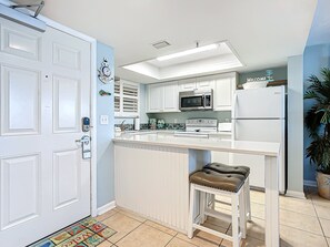 Sleek kitchen with white cabinetry, modern appliances, and a breakfast bar for casual dining.