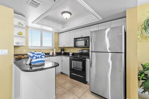 This updated kitchen features stainless steel appliances, granite countertops, and ample cabinet space. Perfect for preparing meals, the kitchen offers a functional and stylish space with a window that brings in natural light.