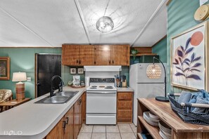 The full kitchen is stocked with dishes, pots & pans, coffee maker, etc...