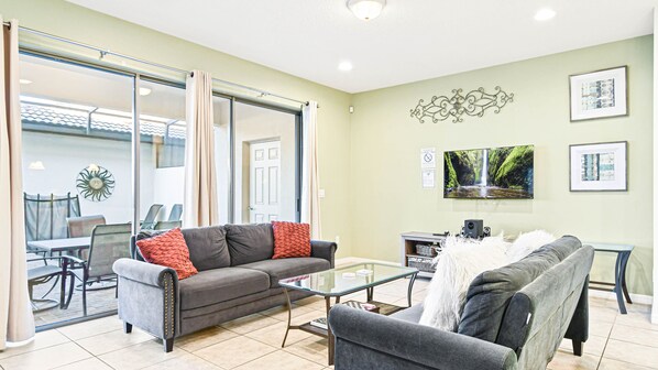 The spacious living room serves as the heart of the home. It features two large, comfortable sofa