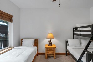 Three comfortable bedrooms await your group with two bedrooms downstairs such as this bedroom with both a twin-over-full bunk bed AND an additional twin bed.