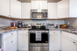 Fully stocked kitchen with granite countertops, stainless steel appliances, and a coffee station to start your day right.

