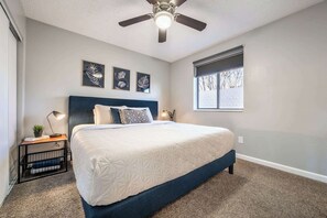 Comfortable king bedroom with soft carpeting, blackout shades, and calming decor for restful nights.