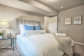 Unwind in Comfort: Queen Bed with Crisp Linens and Bedside Lamp for a Serene Retreat.