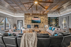 Gorgeous farmhouse living room with beautiful stone fireplace and large Smart TV.