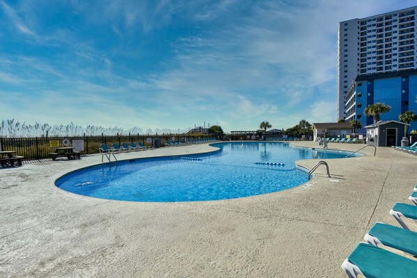 Large oceanfront pool with snack bar, lounge chairs, and picnic tables