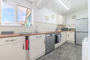 Fully equipped kitchen with electric oven and hob, dishwasher, microwave and two fridges