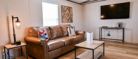 Comfortable leather couch and TV for relaxing.