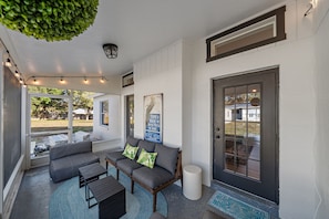 The beautiful covered porch with string lights and a cozy furniture set is the perfect spot for your morning cup of coffee :)