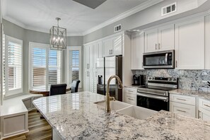 Fully Equipped Kitchen with Pristine White Cabinetry, Granite Countertops and Eat-In Table Space