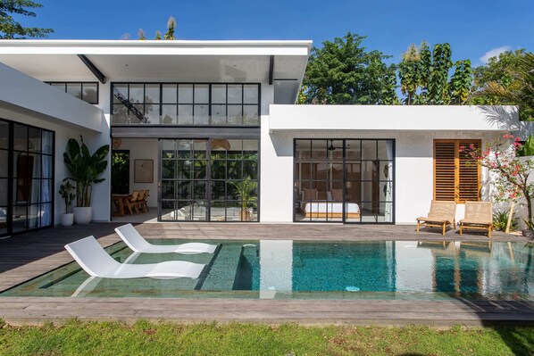 Outdoor area with a large swimming pool and daybeds