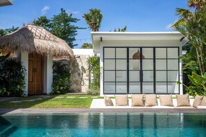 Outdoor area with a large pool, sunken lounge, and cabana.
