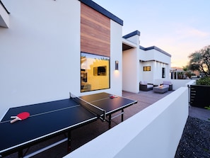 Front Patio featuring a Ping Pong table for friendly competition, and a cozy fireplace for those cool desert nights.