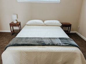 Relax in a queen-sized bed with bedside tables and a lamp.