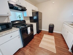 The kitchen is stocked with cookware, dinnerware, and appliances to meet all your cooking needs