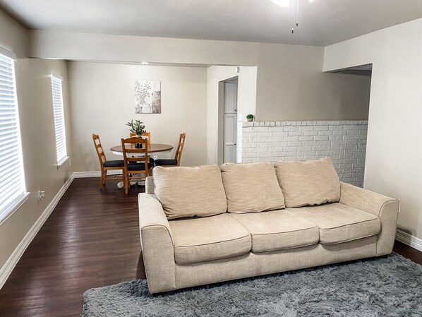 The open living and dining includes a comfortable couch in front of the TV.