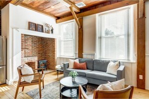 Living room area with electric stove in the inglenook fireplace