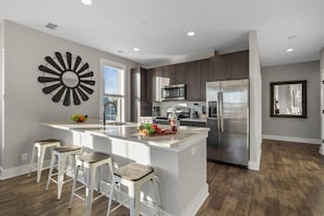 Fully equipped kitchen stocked with your basic cooking essentials, stainless steel appliances, and breakfast bar seating.