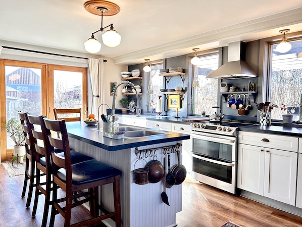 Chef's kitchen is equipped with double ovens, bar seating for 4, dishwasher
