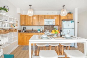 Fully equipped kitchen with full-size appliances, plus dining table with 5 bar stools, cabinets, and shelves for your kitchen utensils.