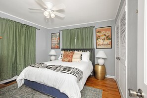 Tranquil bedroom with green curtains and vintage charm.