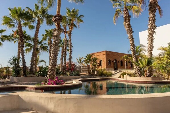 The view from the pool back to the main house (brick) and studio (white).