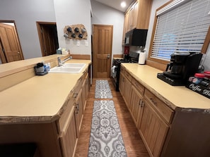 Galley Kitchen with dishwasher, oven, gas cooktop, refrigerator and microwave