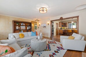 Living room connecting kitchen to hallway with two bedrooms and a bathroom