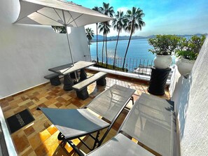 Terrace with table, umbrella, and lounge chairs