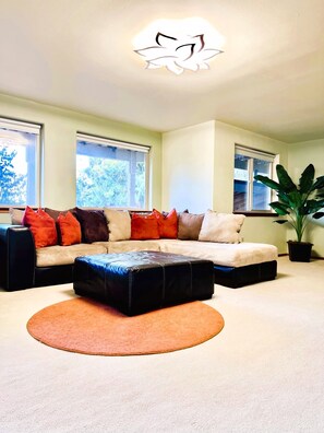 Entertainment room with large comfortable sectional, television and fireplace. 