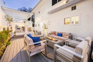 Cushioned seats adorning the large outdoor living area with firepit.