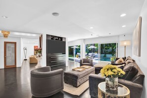 A striking mid-century marble gas fireplace divides the living room from a relaxed seating area.