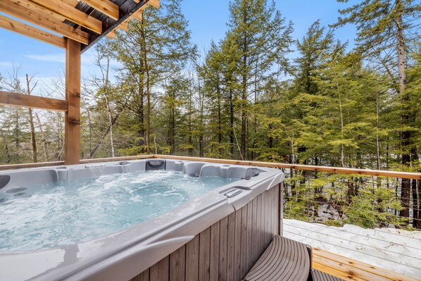 Hot tub on the back deck with views of the woods.