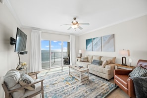 Living room that offers a breathtaking Gulf view, sleeper sofa, 1 recliner, 1 arm chair and a 55" wall mounted SMART TV