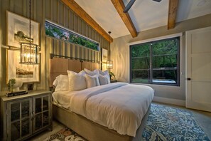 The master suite features a king-size bed with crisp, clean bedding.