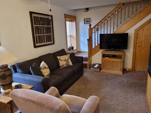 Livingroom with pull out sofa bed, TV, and  electric fireplace.