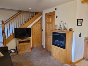 Livingroom with pull out sofa bed, TV, and  electric fireplace.