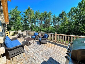Spacious deck with dining table, seating area, and grill