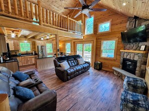 Main Level Living Area with gas fireplace, TV, recliners, and slider access to the deck.