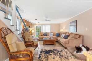 Living room featuring a large sectional couch and smart TV with the ability to log into personal streaming platforms. Note: Fireplace is inoperable