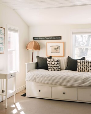 There's a pullout King Size daybed right off the dining + kitchen area with a sliding barn door for full privacy.